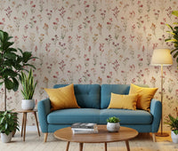 Soft Floral Whispers wallpaper of delicate pink wildflowers on cream behind a teal sofa with yellow cushions