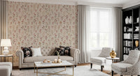 Soft Floral Whispers wallpaper of scattered blooms behind a tufted cream sofa with dark floral pillows