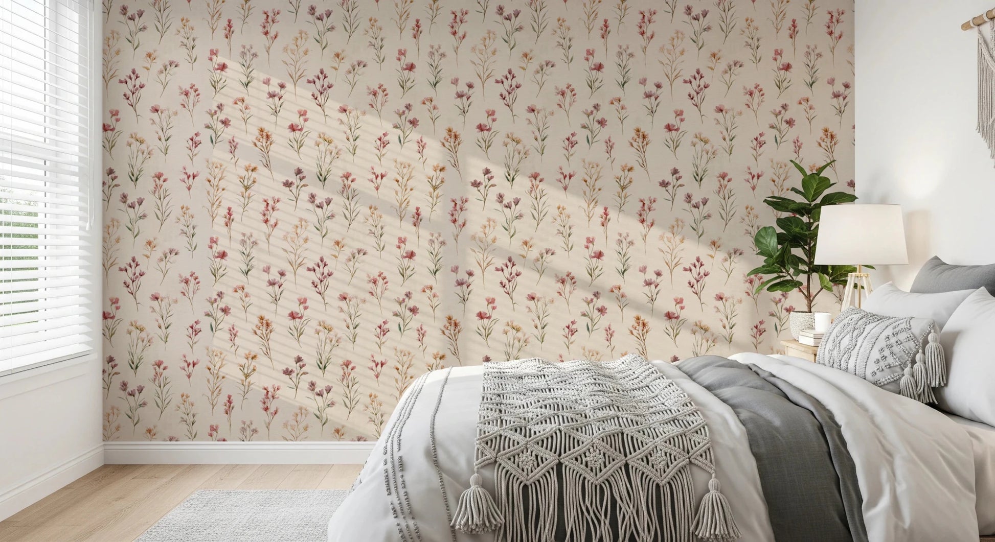 Soft Floral Whispers wallpaper of delicate blooms in a bedroom behind a grey bed with a macrame throw
