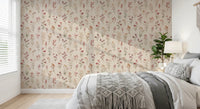 Soft Floral Whispers wallpaper of delicate blooms in a bedroom behind a grey bed with a macrame throw