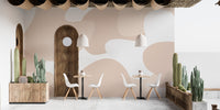 Soft Pastel Abstract wallpaper mural in peach and cream shapes behind cafe tables and cactus planters