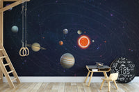 Solar System Planets Orbit wallpaper mural in a kids playroom with wooden gym rings and a Cool Kids chalkboard sign