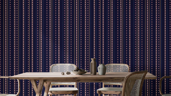 Starry Indigo Waltz wallpaper in navy with dotted stripes behind a wooden dining table and rattan chairs in a dining room