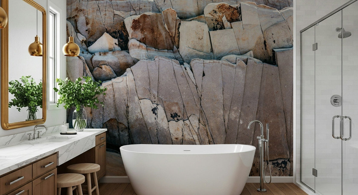Stone Geometry wallpaper mural of cracked beige and rust rock behind a white freestanding tub in a bright bathroom