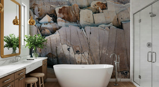 Stone Geometry wallpaper mural of cracked beige and rust rock behind a white freestanding tub in a bright bathroom