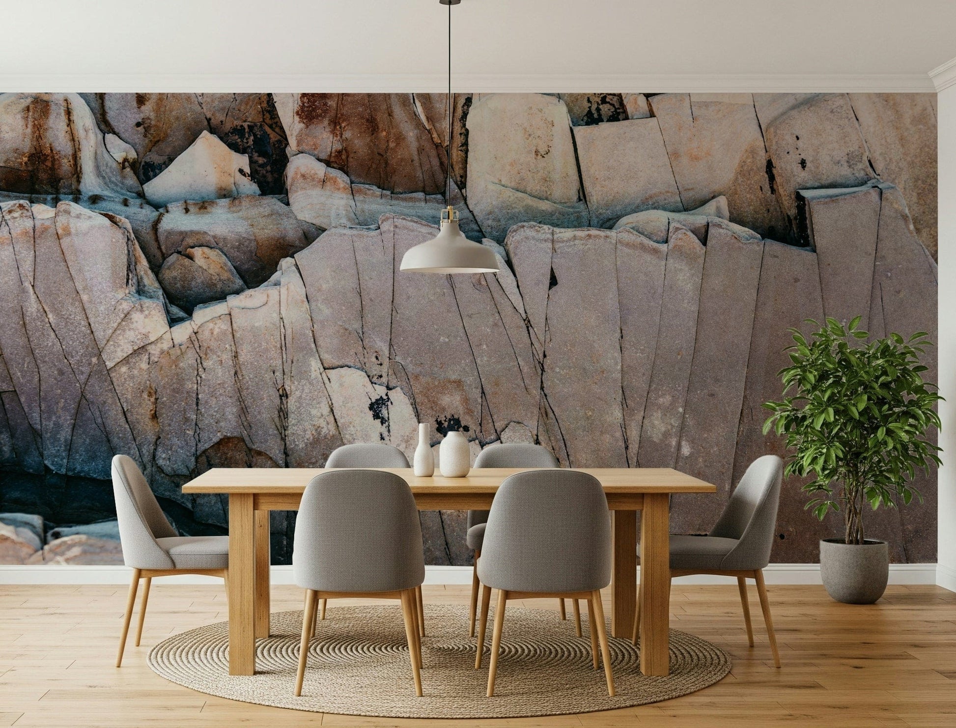 Stone Geometry wallpaper mural of rust and grey rock above a wood dining table with grey chairs in a dining room