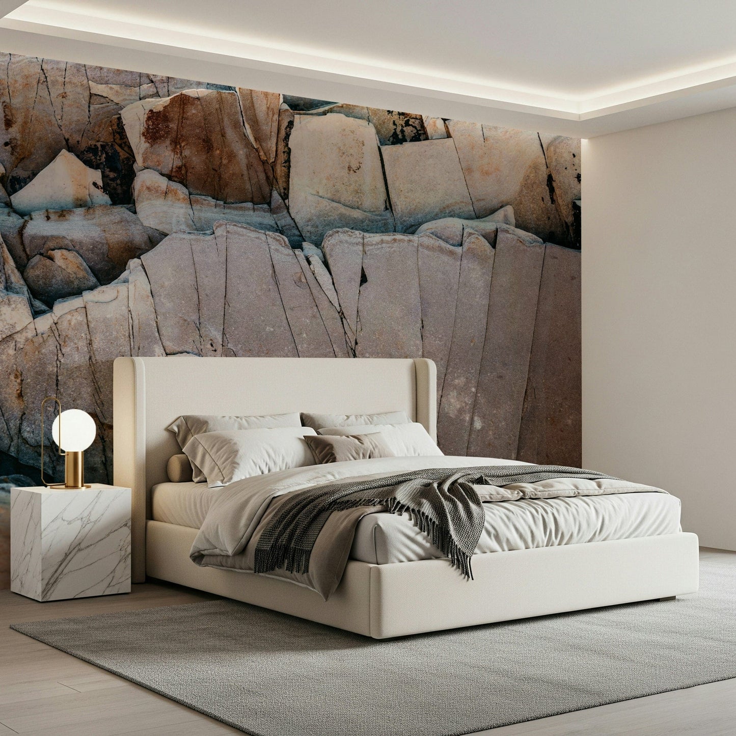 Stone Geometry wallpaper mural of cracked rock behind a cream upholstered bed with white bedding in a bedroom