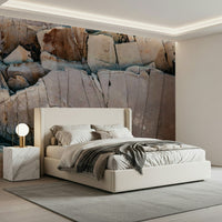 Stone Geometry wallpaper mural of cracked rock behind a cream upholstered bed with white bedding in a bedroom