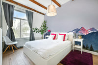 Sunset Mountain Vista wall mural behind a white bed with pink pillows and a plum rug in a bedroom