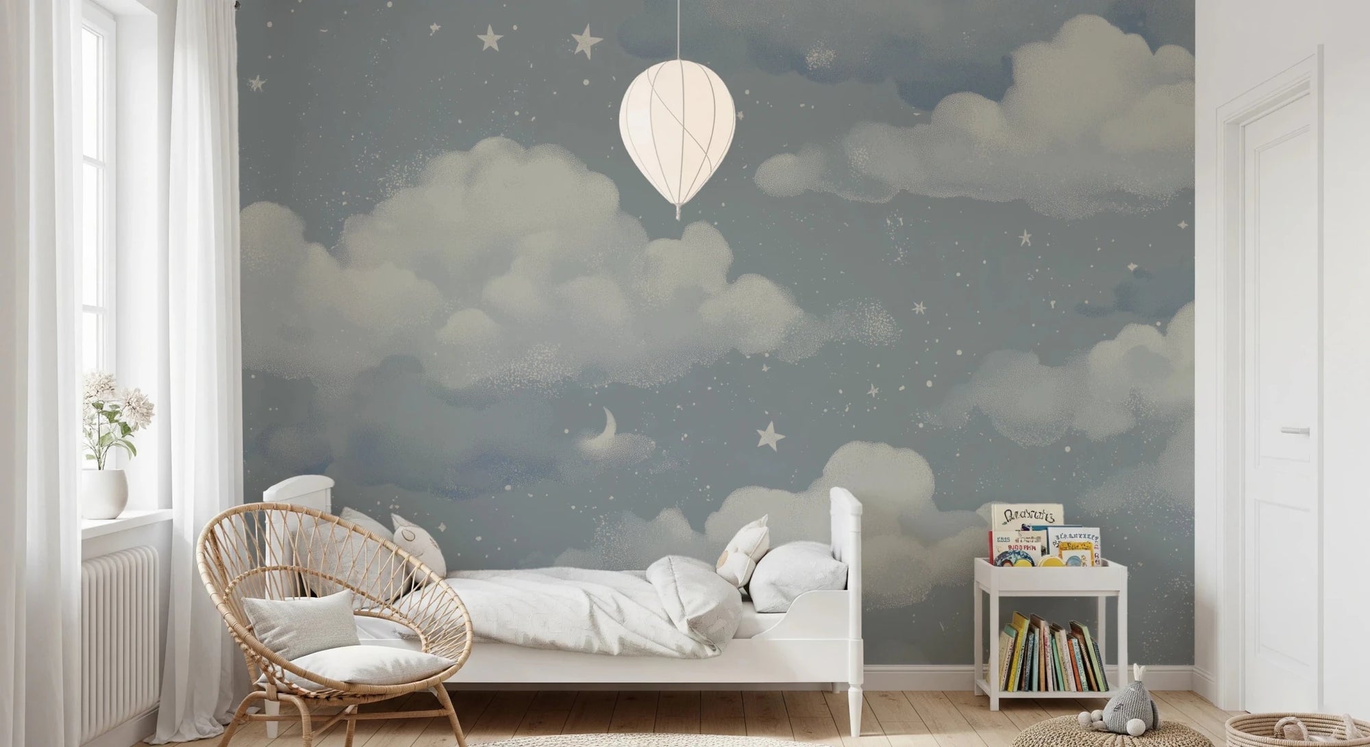 Sweet Dreams Blue wallpaper mural of slate-blue clouds and stars in a kids bedroom with a white bed and rattan chair
