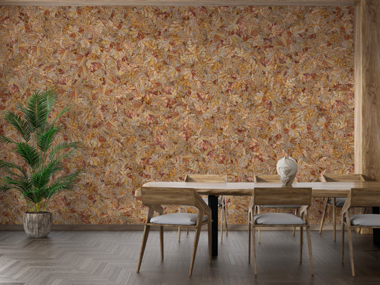 Taupe Brown Autumn Leaf wallpaper mural behind a wood dining table with cushioned chairs and a potted palm