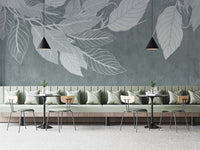 Elegant Teal Botanical Leaf wallpaper mural with pale leaf silhouettes behind a sage banquette and bistro tables in a cafe