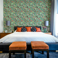 Flying Butterflies Colorful Teal Coral wallpaper above a bed with orange and navy pillows and velvet ottomans
