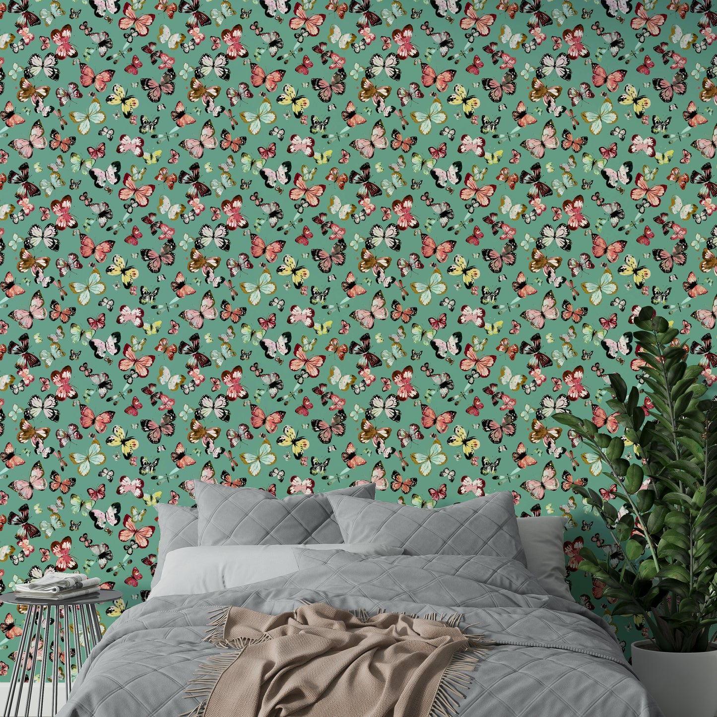 Flying Butterflies Colorful Teal Coral wallpaper above a grey quilted bed with beige throw and a green plant