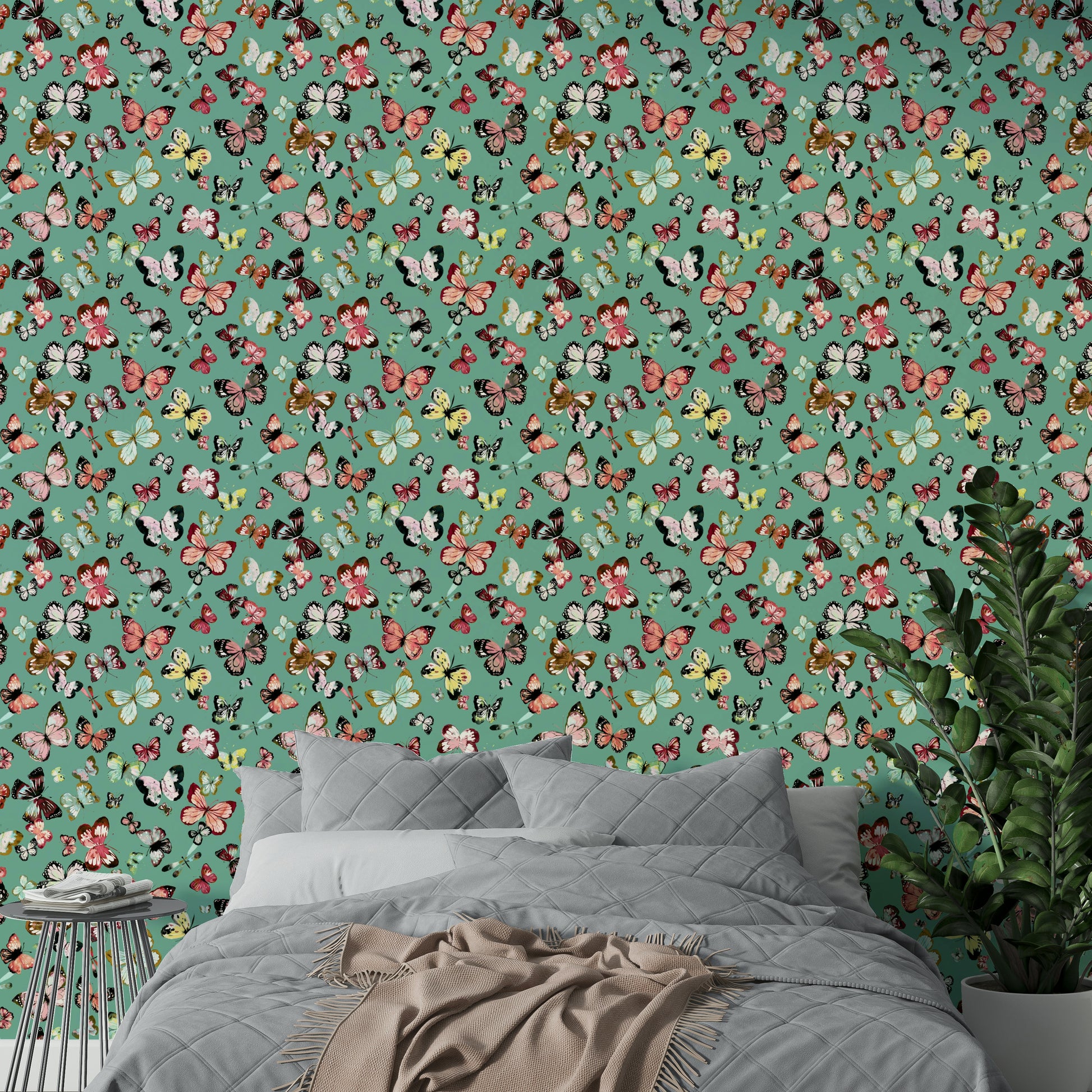 Flying Butterflies Colorful Teal Coral wallpaper above a grey quilted bed with beige throw and a green plant