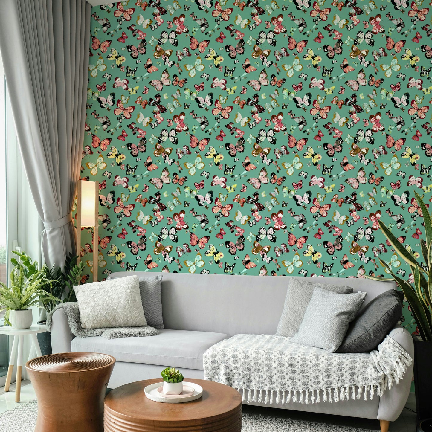 Flying Butterflies Colorful Teal Coral wallpaper behind a light grey sofa with throw and plants in a living room