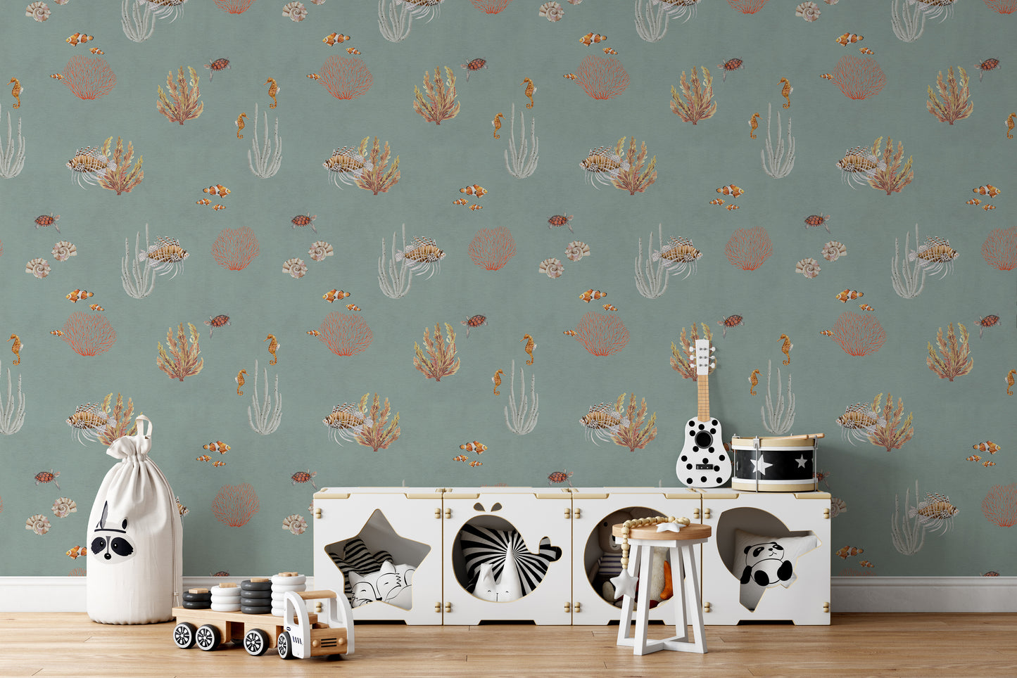 Teal Oceanic Wonders wall mural behind a white toy cabinet with a guitar and toy drum