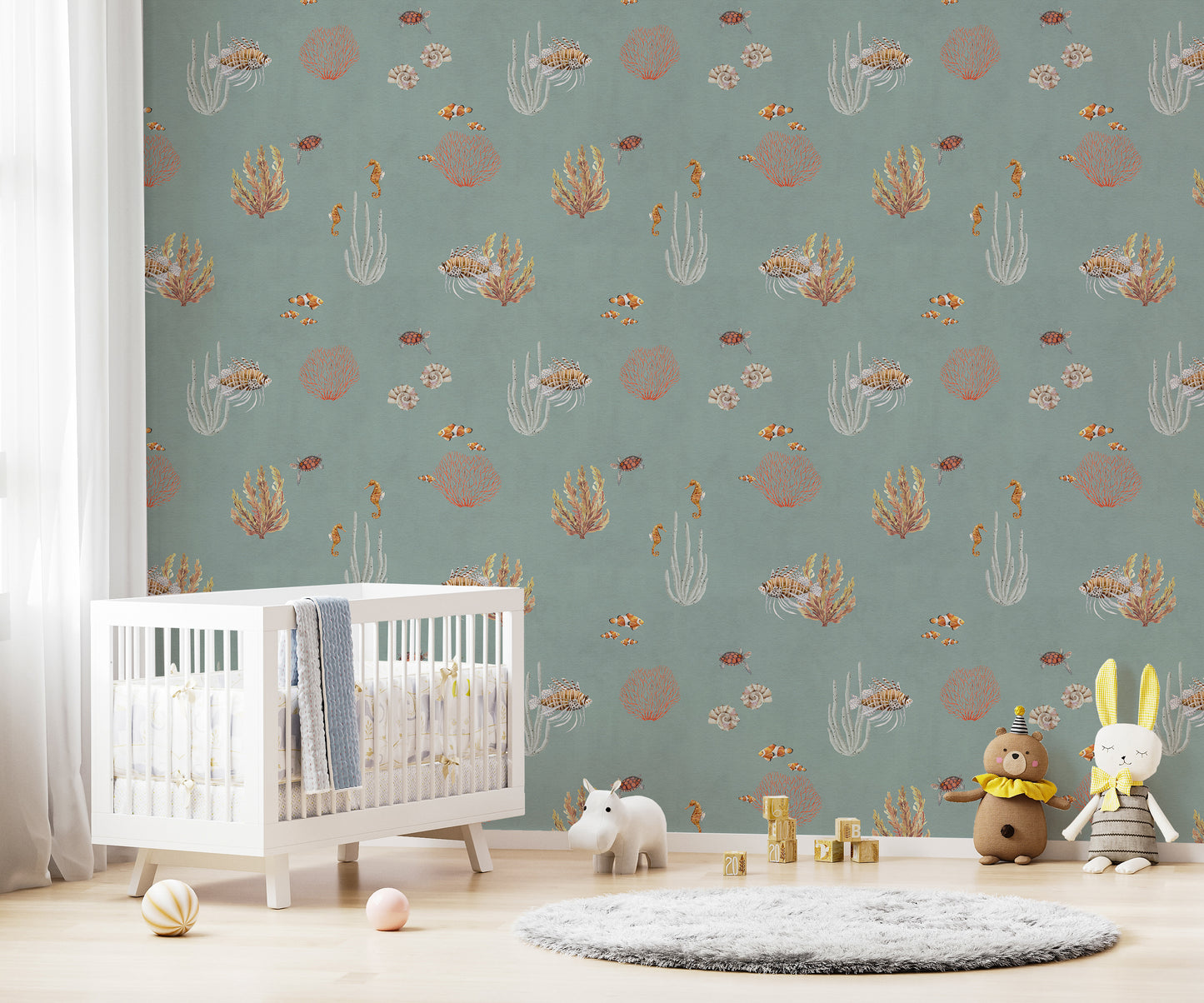 Teal Oceanic Wonders wall mural over a white crib with a hippo toy and plush animals in a nursery