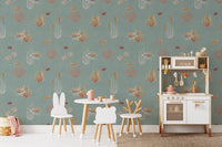 Teal Oceanic Wonders wall mural beside a white play kitchen and bunny chairs in a kids room