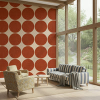 Beige wallpaper decorated with large terracotta dots that have a subtle fabric-like texture