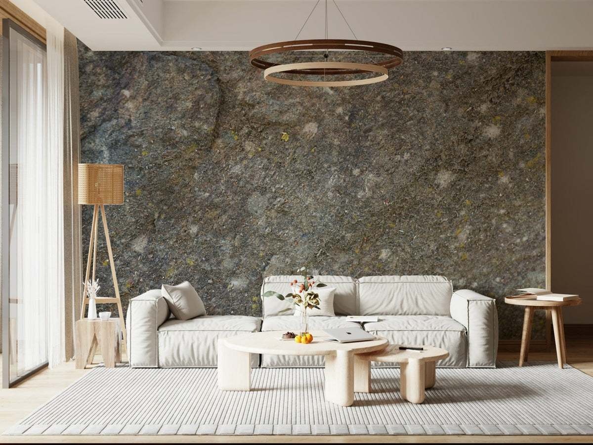 Textured rock surface wallpaper mural behind a white sofa with a wooden ring chandelier in a living room