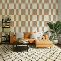 Textured Taupe & White checkerboard wallpaper mural behind a tan leather sectional and ladder shelf