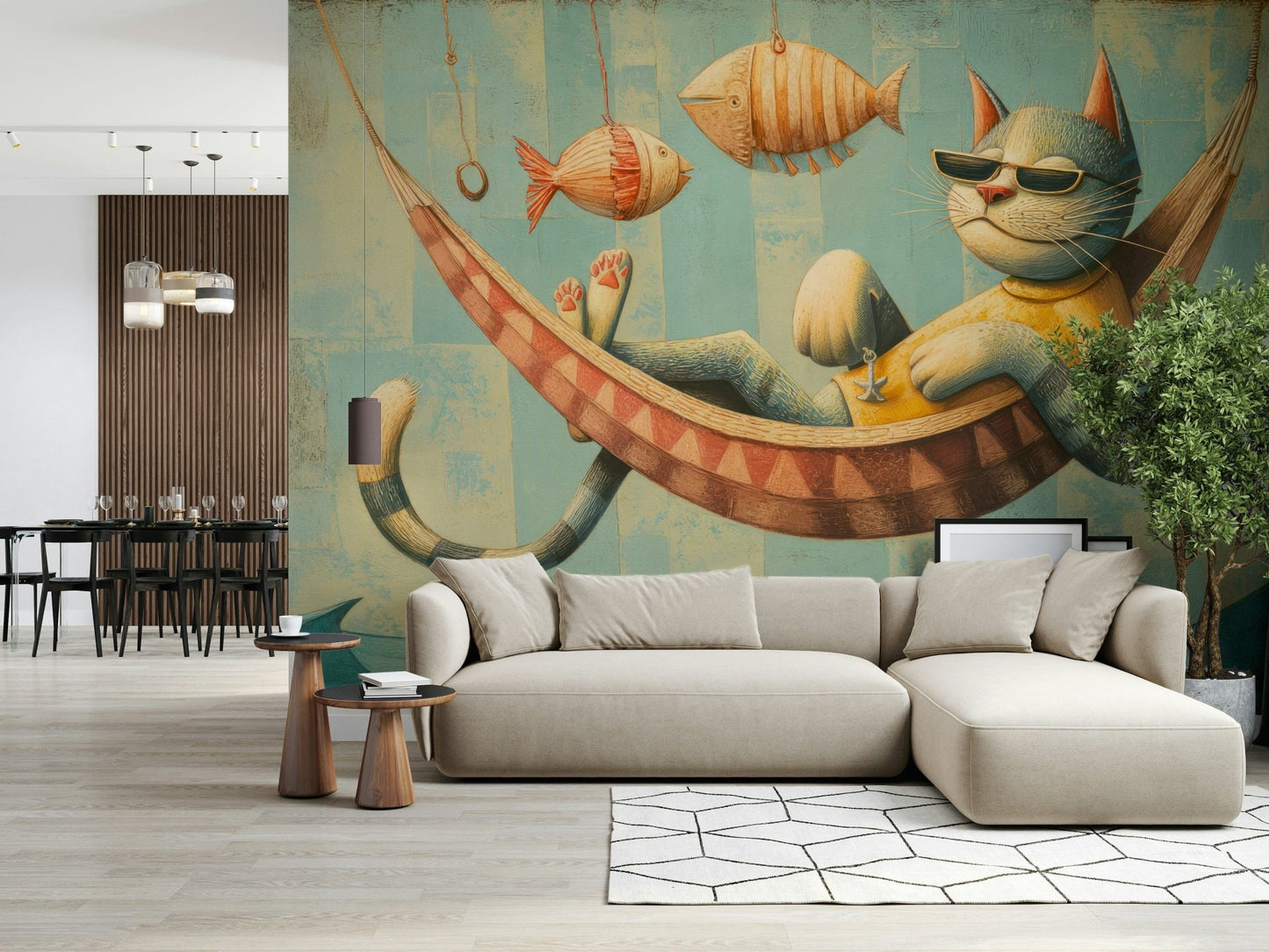The Cat's Seaside Siesta wallpaper mural above a beige sectional sofa with a dining area in a bright open room