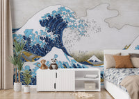 The Great Wave Kanagawa wallpaper mural with Mt Fuji behind a white sideboard and bed with blue bedding in a kids room