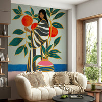 The Keeper of Oranges wallpaper mural with a folk-art woman and oranges above a cream boucle sofa in a living room
