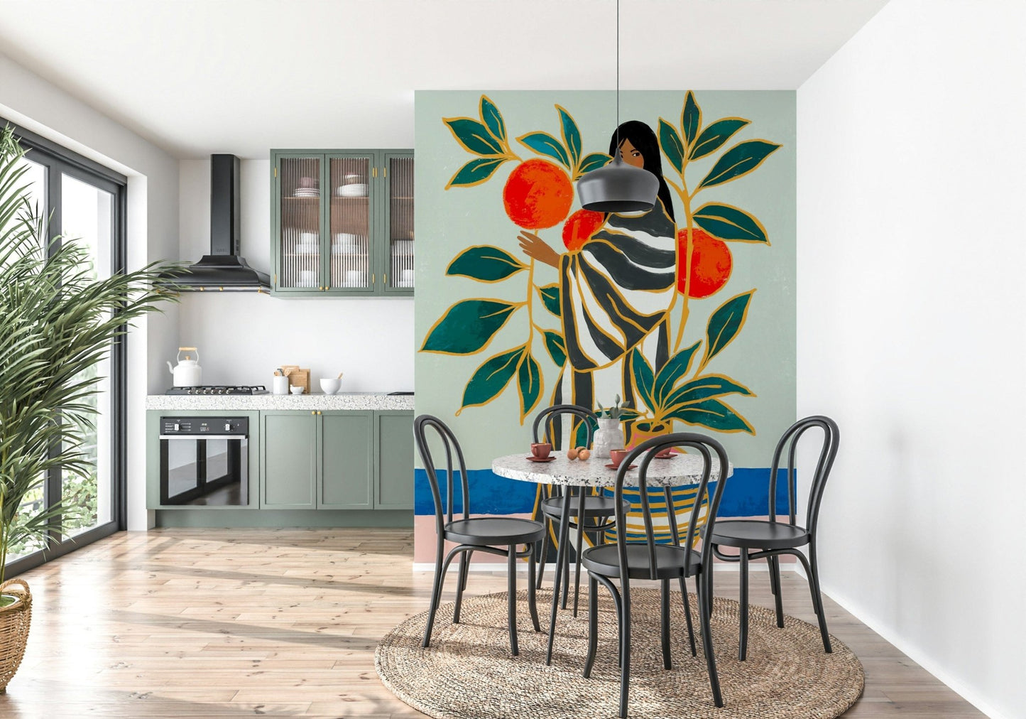 The Keeper of Oranges wallpaper mural beside a round terrazzo table and black bistro chairs in a green kitchen