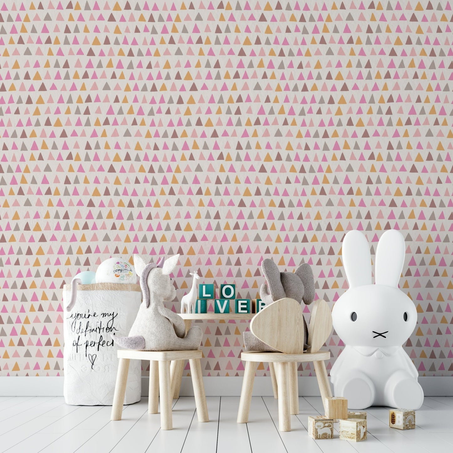 Hand-drawn triangle shapes in shades of pink on wallpaper.

