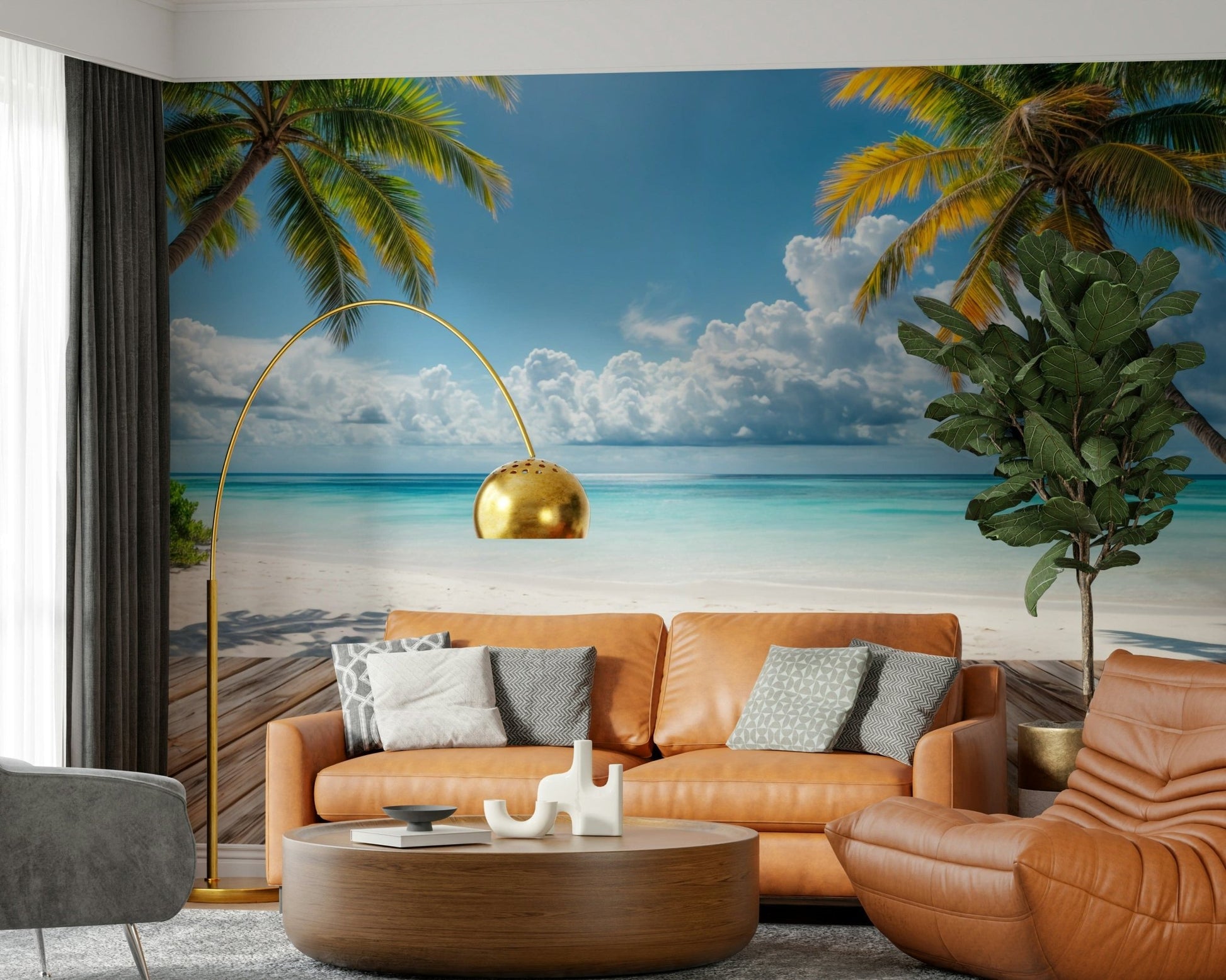 Tropical Beach View wallpaper mural behind a caramel leather sofa and gold arc lamp in a living room with a fiddle-leaf plant