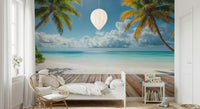 Tropical Beach View wallpaper mural of palms and ocean above a white daybed and rattan chair in a kids room
