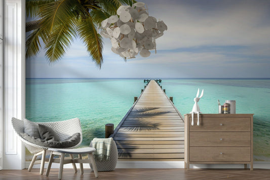 Tropical pier wall mural in modern living room, palm trees, ocean blues, feature wall behind sofa