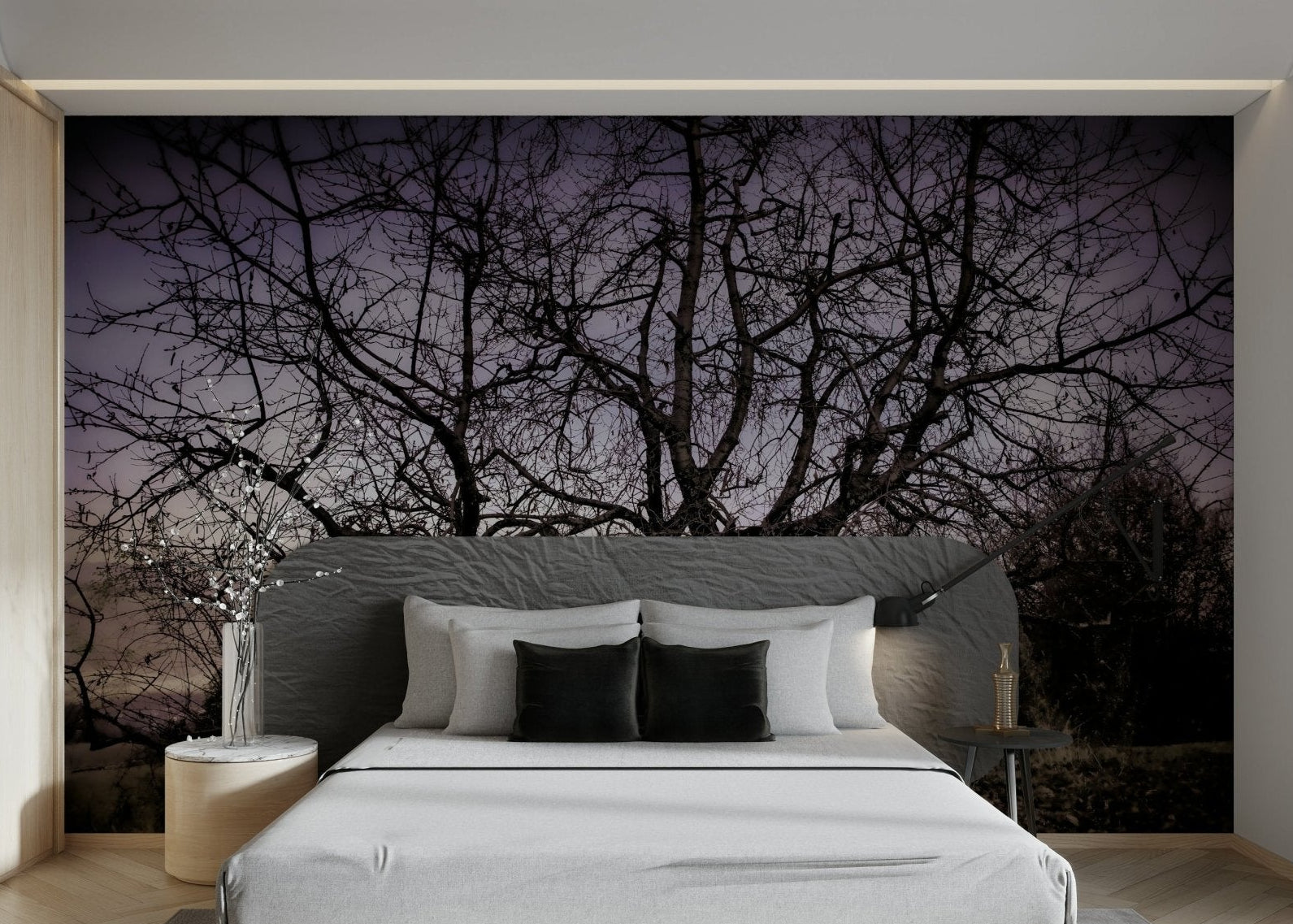 A black-and-white wall mural of a twisted, barren tree silhouette.
