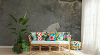 Urban Gray Industrial wallpaper mural in gray concrete behind a rattan sofa with tropical floral pillows