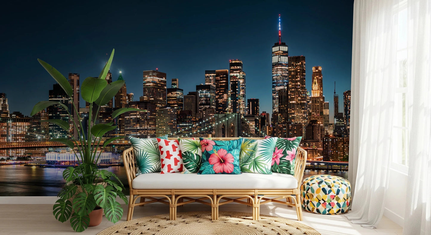 Urban Nightscape wallpaper mural behind a rattan sofa with tropical hibiscus cushions and leafy plants