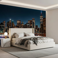 Urban Nightscape wallpaper mural of New York at night behind a cream upholstered bed in a modern bedroom