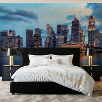 Urban Serenity wallpaper mural of skyscrapers over water behind a black bed with gold lamps and black nightstands