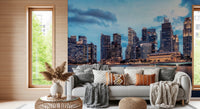 Urban Serenity wallpaper mural of skyscrapers under a blue sky behind a white sofa with knit and leather pillows