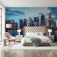 Urban Serenity wallpaper mural of a waterfront skyline behind a cream tufted bed with a pink accent chair