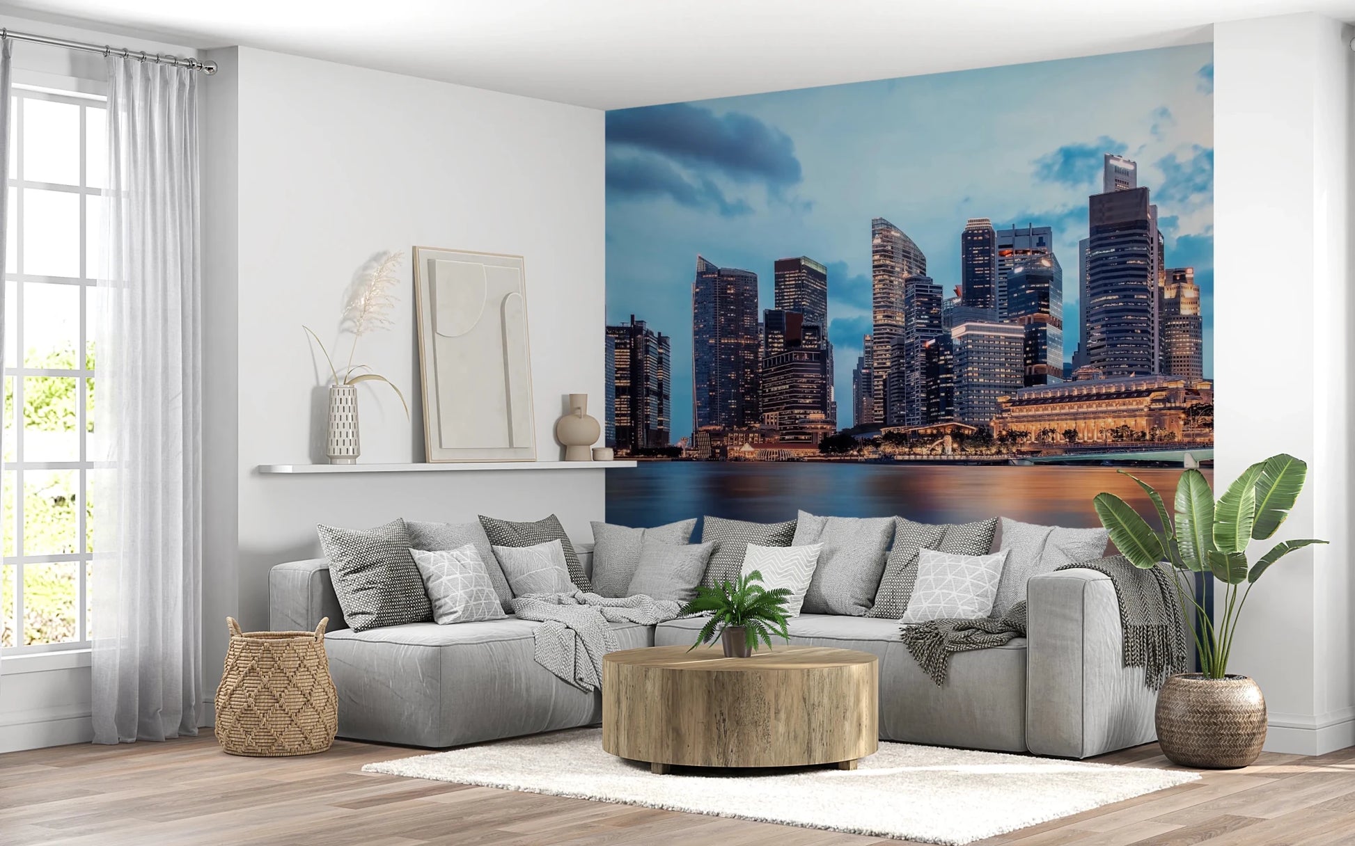 Urban Serenity wallpaper mural of skyscrapers under a blue sky behind a large gray sectional sofa and round wood table