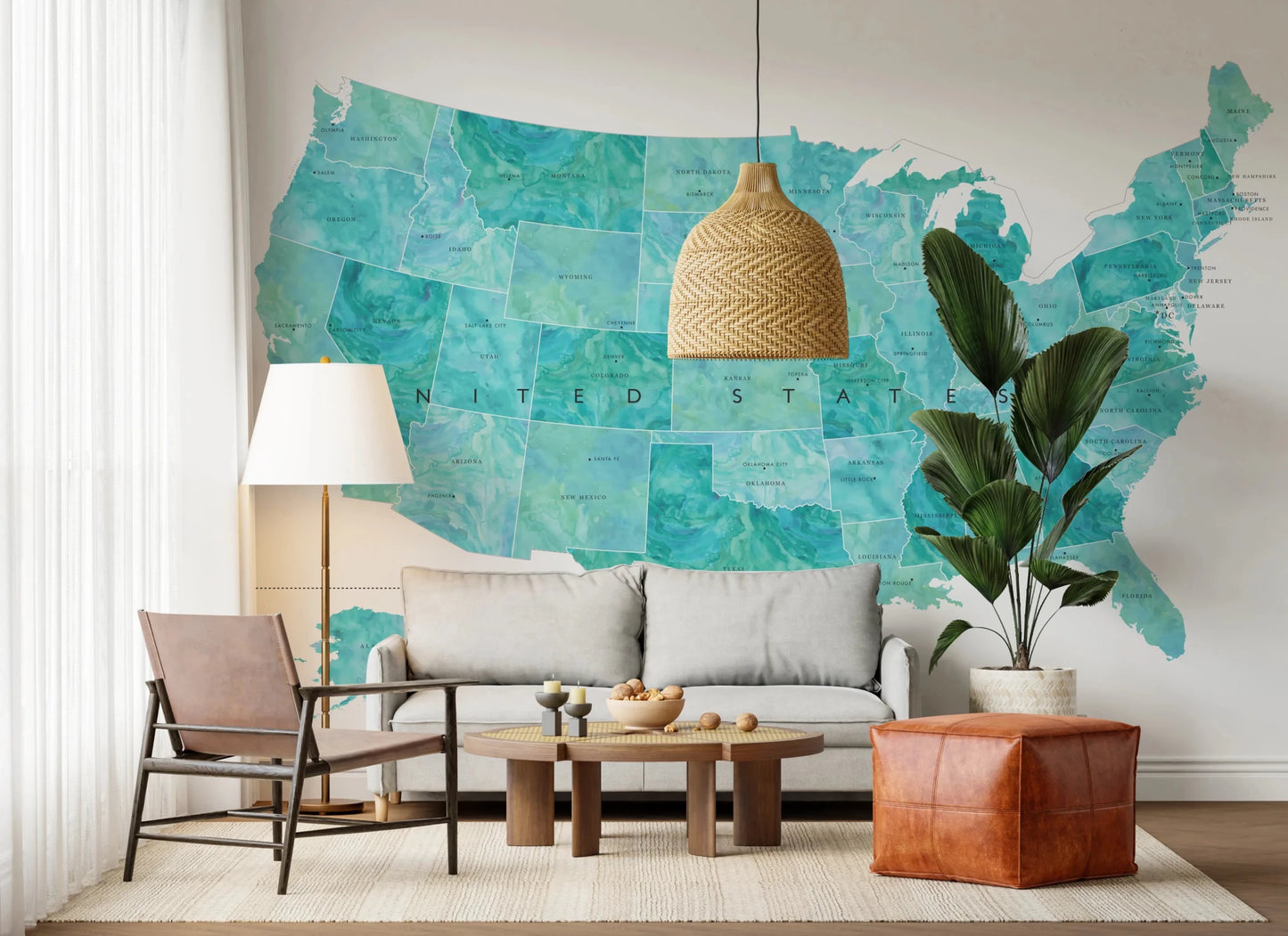 USA map with states and capitals in teal watercolor wallpaper mural behind a grey sofa with a rattan pendant light