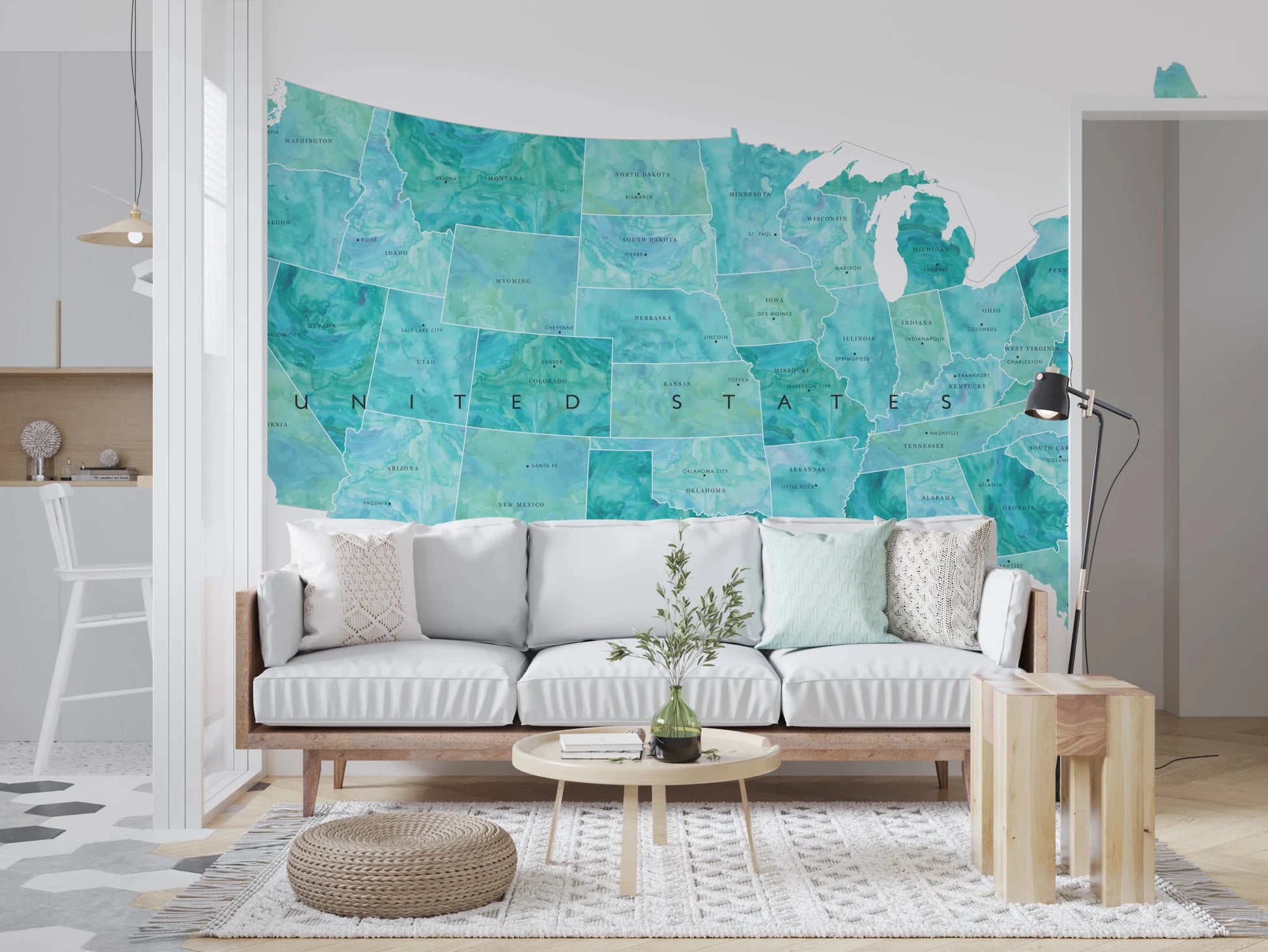 USA map with states and capitals in teal watercolor wallpaper mural above a white sofa in a bright living room