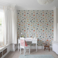 Vehicles in blue background wallpaper above a white desk with red chair in a bright bay-window child's room