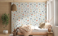 Vehicles in blue background wallpaper behind a wood daybed with striped bedding and rattan pendant lamp