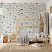 Vehicles in blue background wallpaper behind a wooden house bed with grey knit throw in a kids room