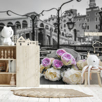 Venetian Blooms wallpaper mural of pink and cream roses on grey Venice scene above a wooden toy shelf in a child's nursery room