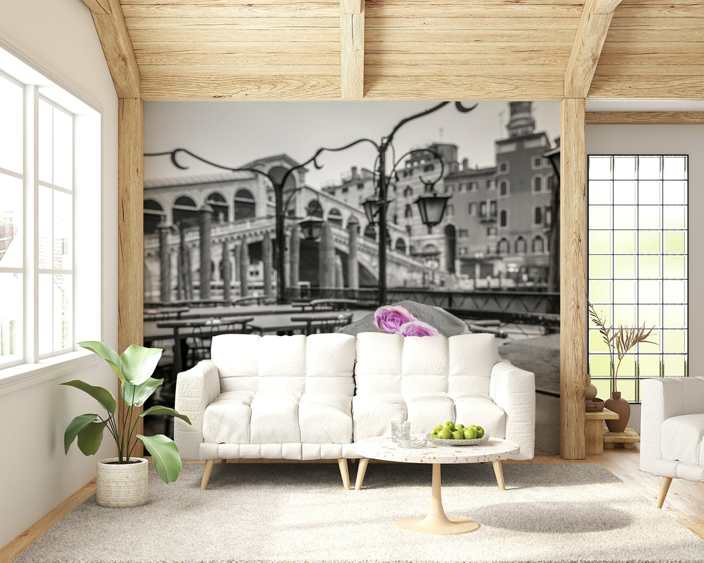 Venetian Blooms wallpaper mural with monochrome Venice bridge and pink roses behind a white sofa and marble coffee table in a living room