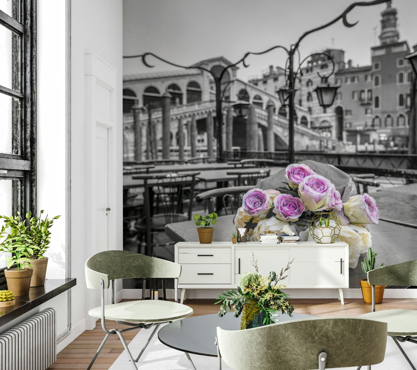 Venetian Blooms wallpaper mural of roses on grey Venice scene above a white sideboard with green chairs in a bright dining room
